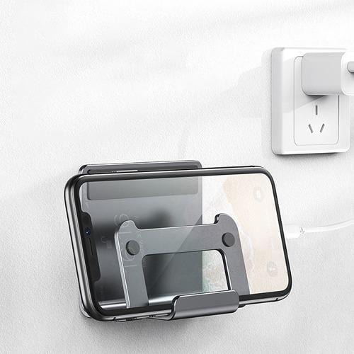 Gray wall holder with phones beside a separate charger