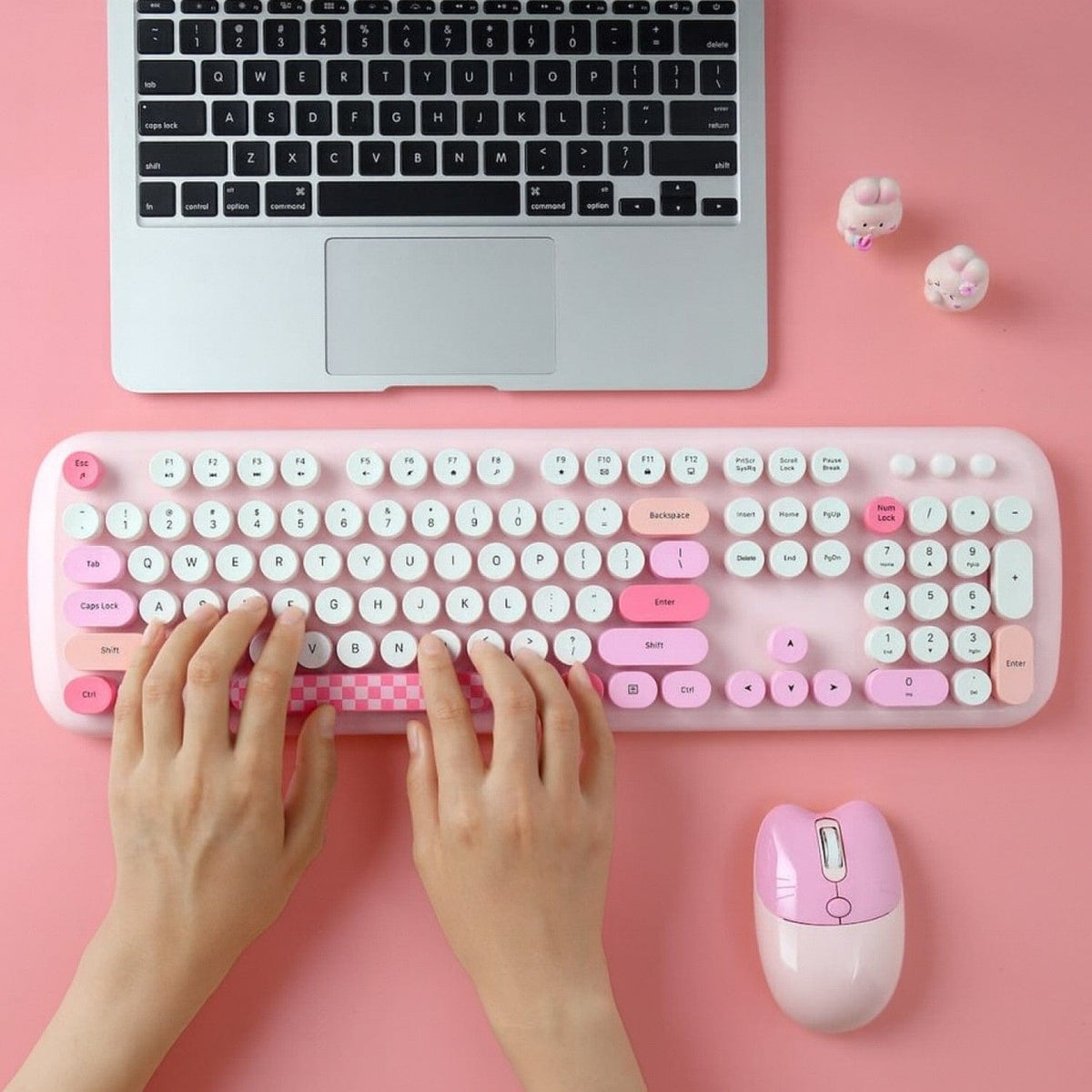 Pink KB10 keyboard being used beside a laptop