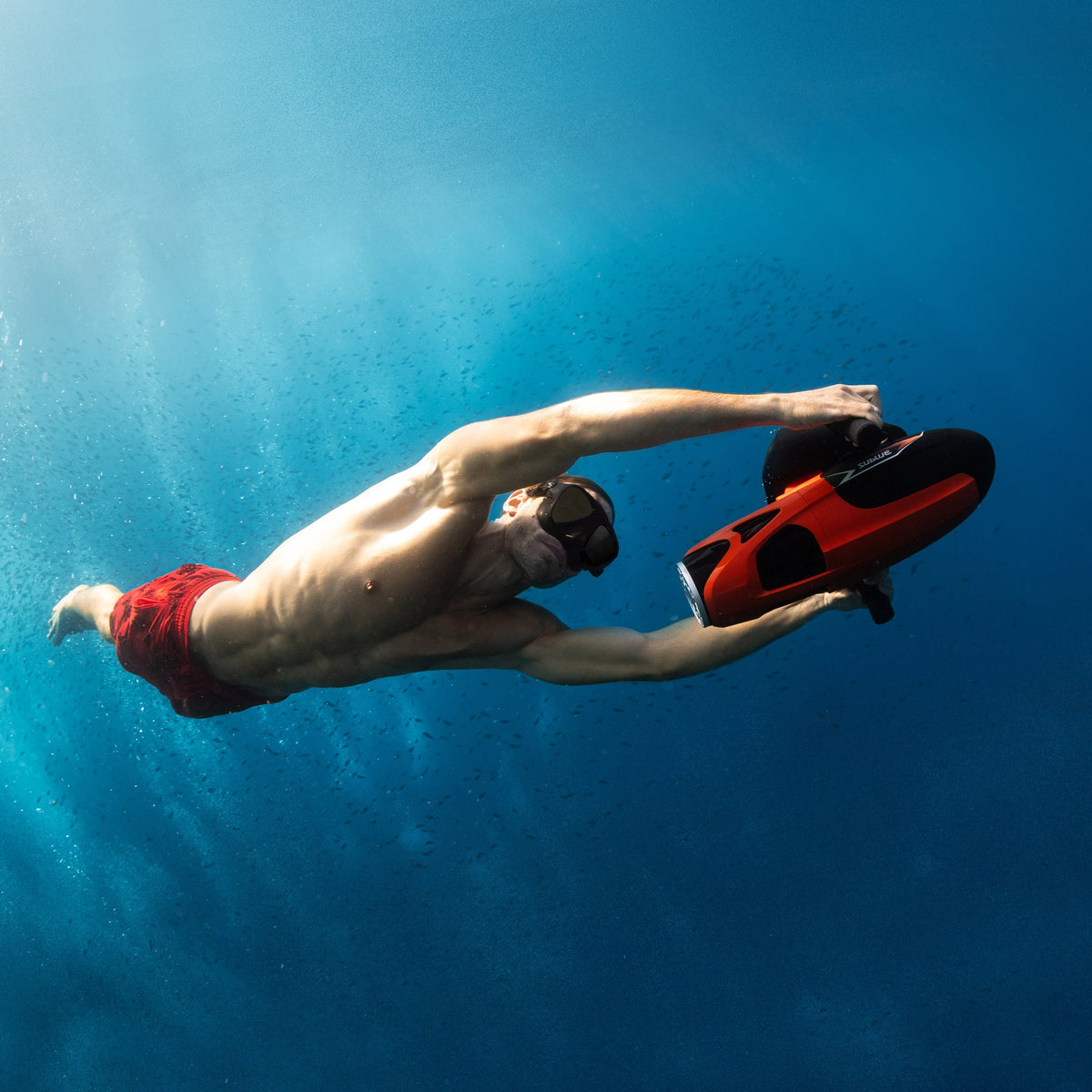 Swimmer holding a red Sublue VAPOR underwater scooter