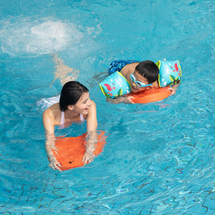 Two swimmers using orange Sublue Swii electric kickboards in a pool