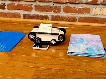 Kitsville Remote-Controlled Tank Building Kit — tank crossing a phone obstacle