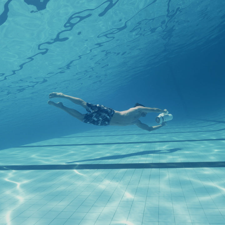 Swimmer using a Sublue EZ underwater scooter in a pool