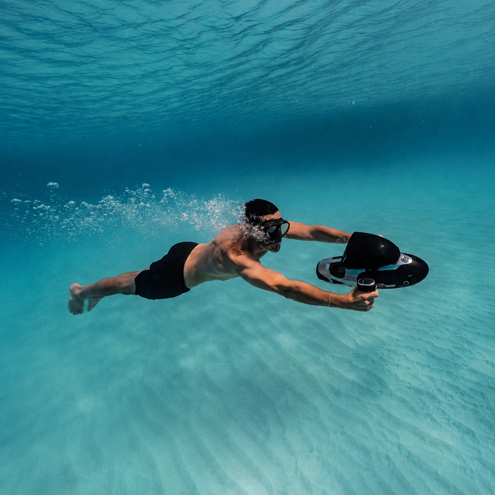 Swimmer using a Sublue VAPOR Pro above a sandy seabed