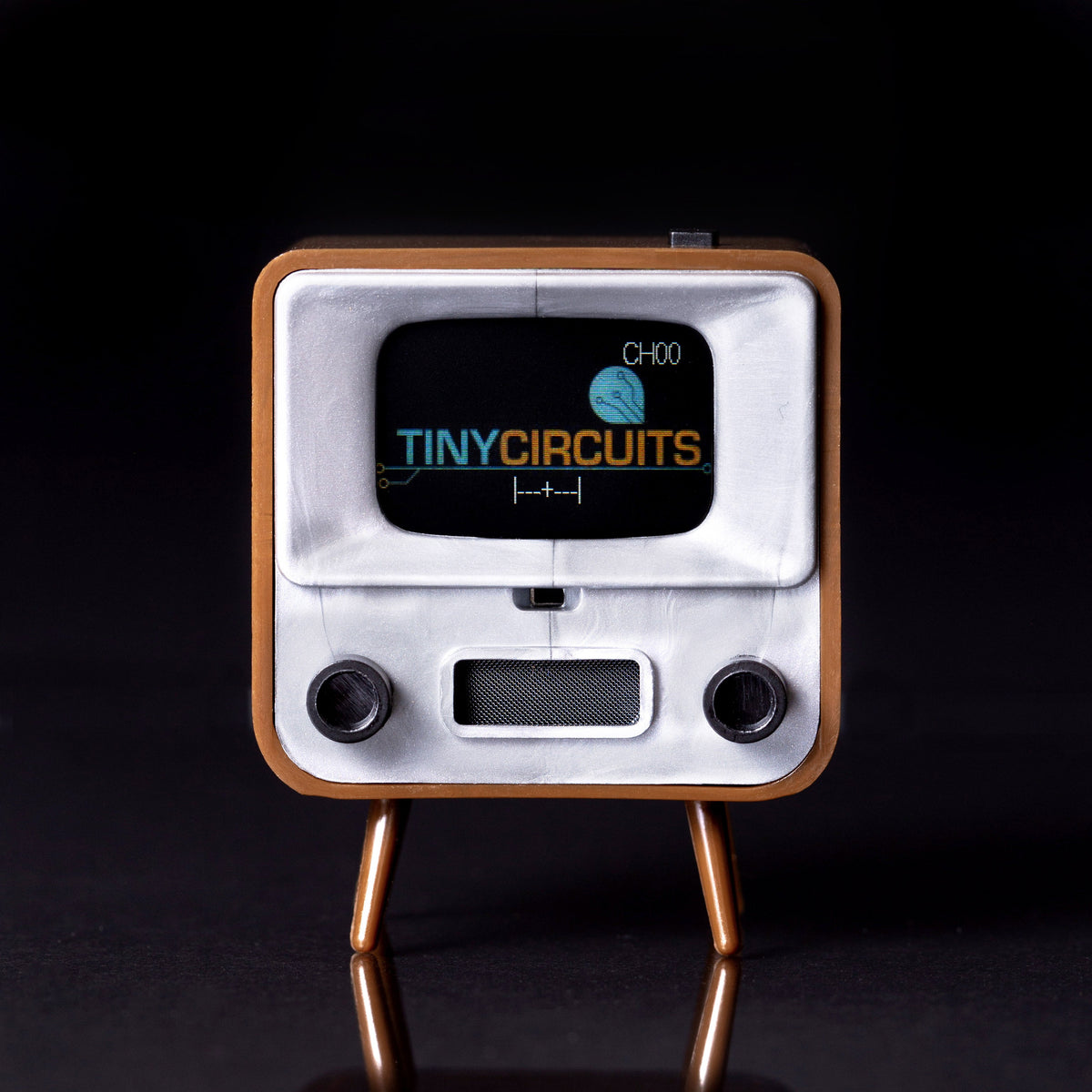 Brown TinyTV 2 standing on a reflective surface