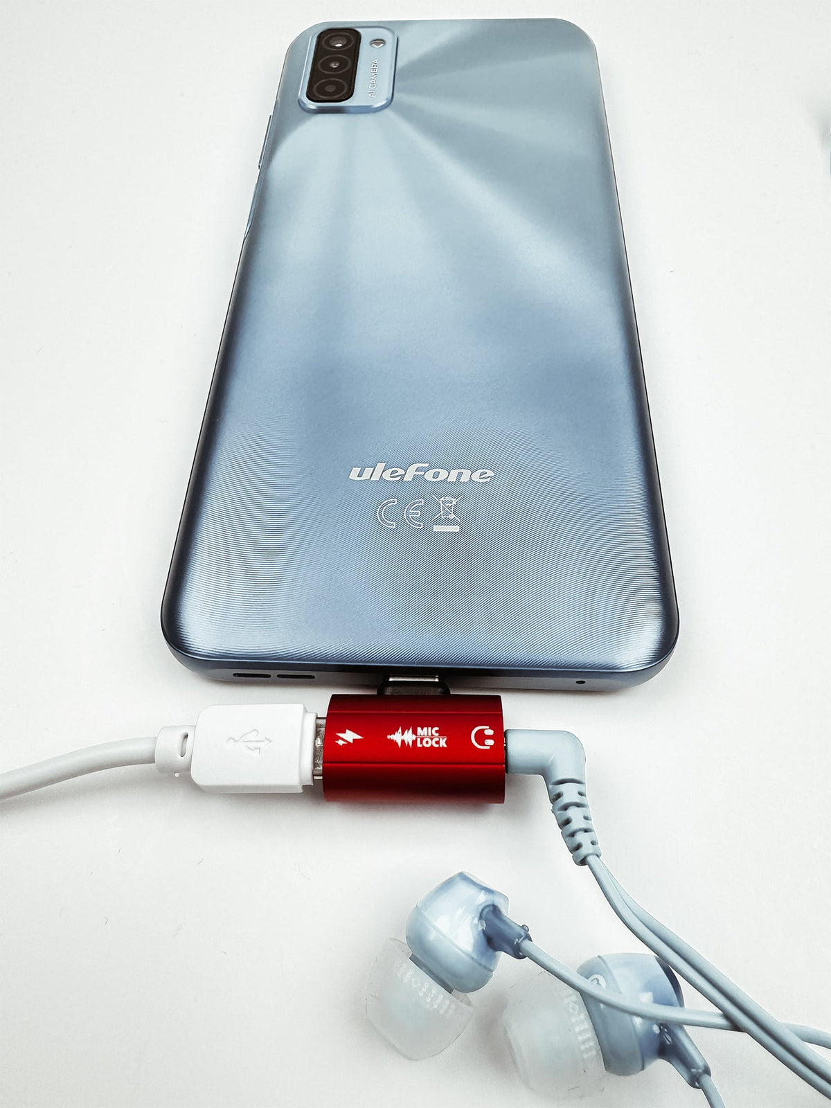 Mic-Lock Red HiFi adapter connected to phone, cable and earbuds