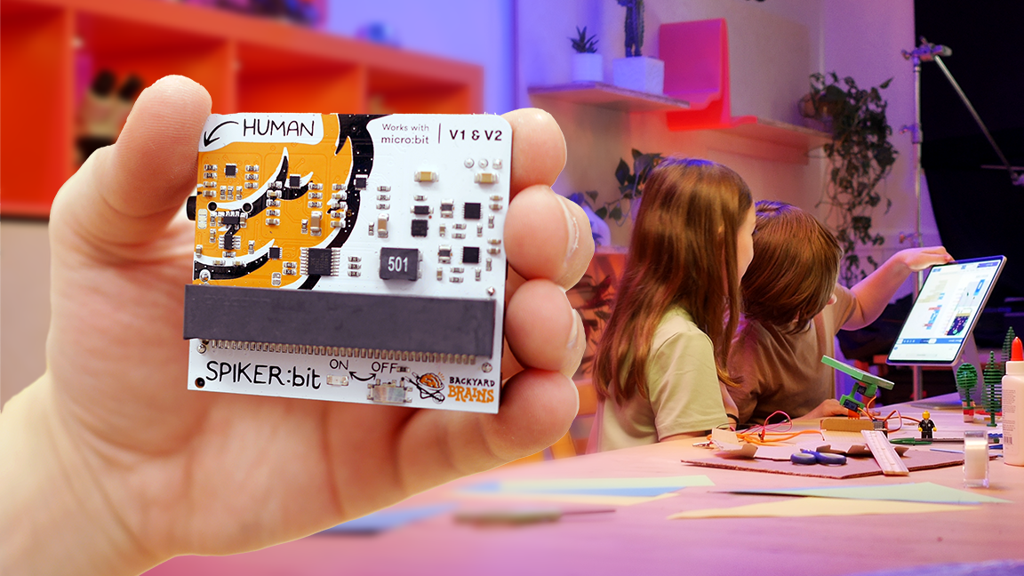 Spiker:bit board held in front of a classroom project space
