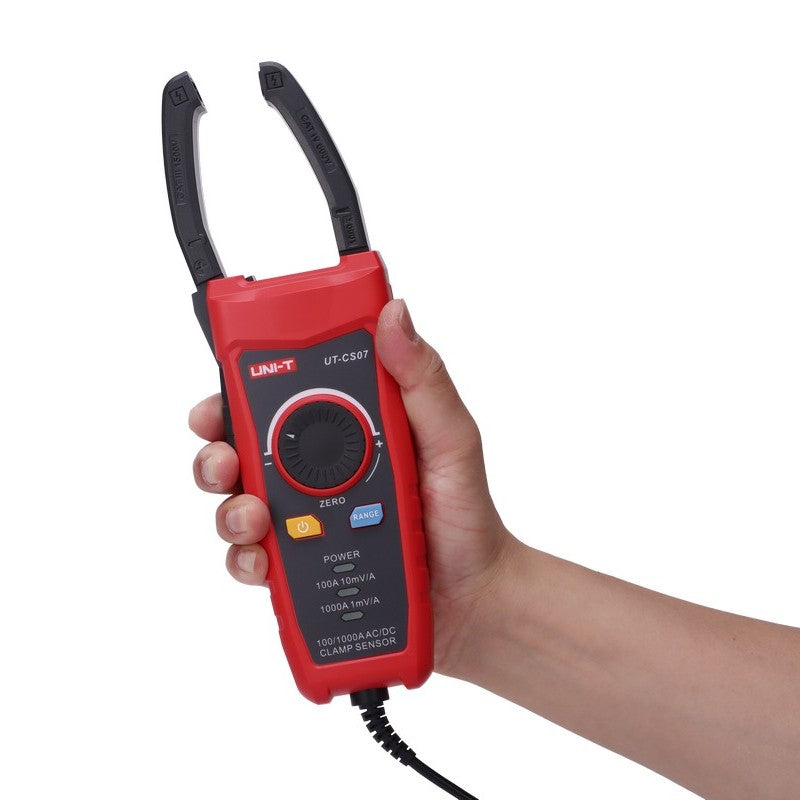 Hand holding the UNI-T UT-CS07 with its clamp jaws open