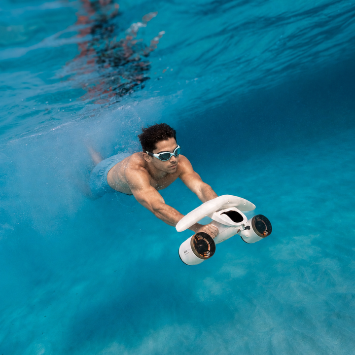 Swimmer using a white Sublue MixPro underwater scooter