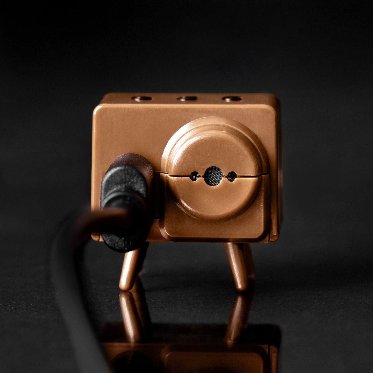 Brown TinyTV Mini rear view with USB-C cable connected; cable sold separately