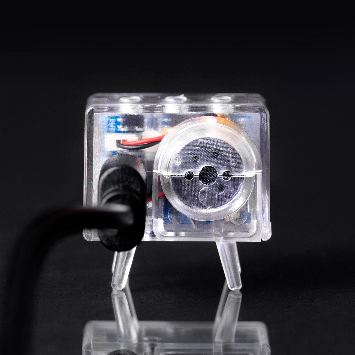 Clear TinyTV Mini rear view with USB-C cable connected; cable sold separately