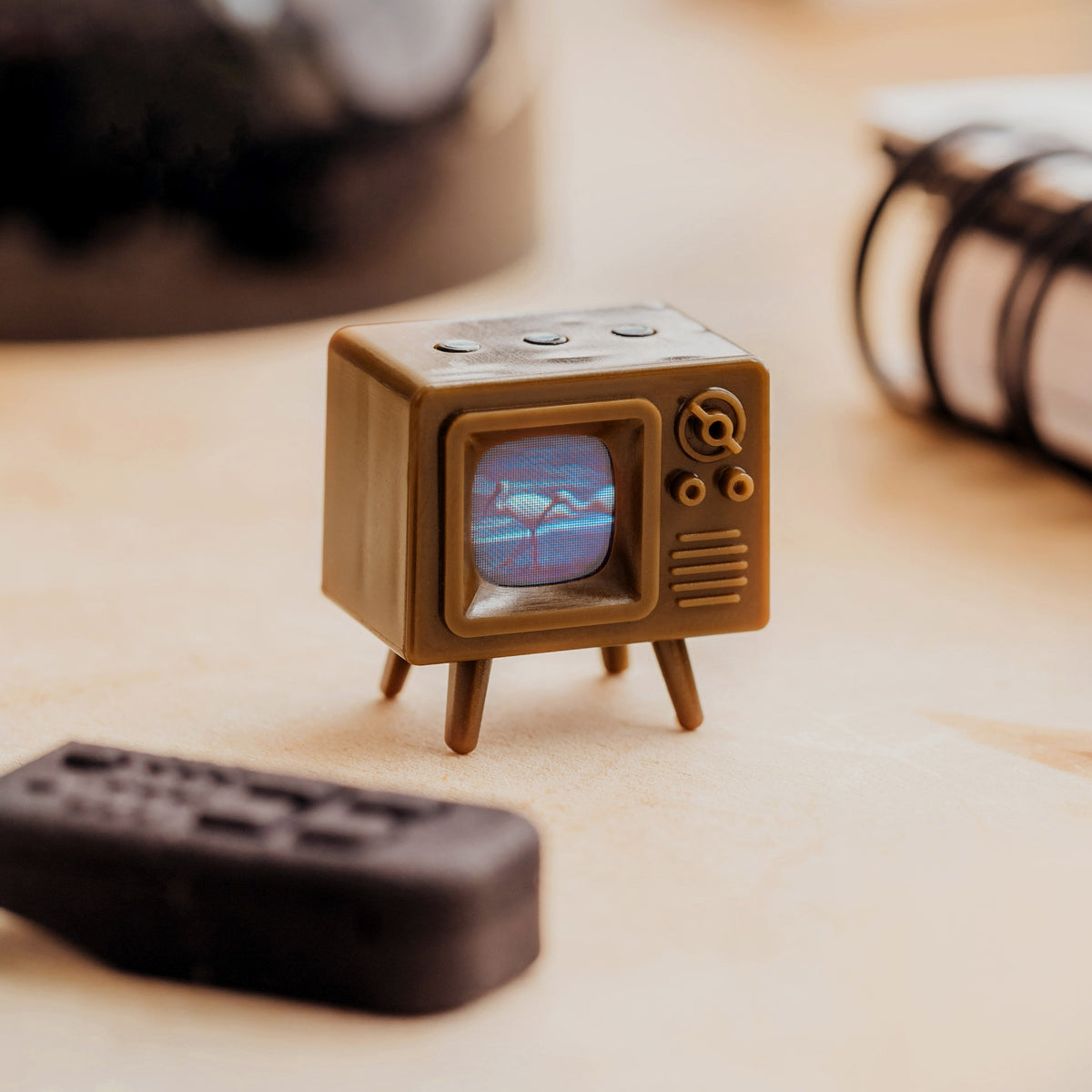 Brown TinyTV Mini with remote on a desk
