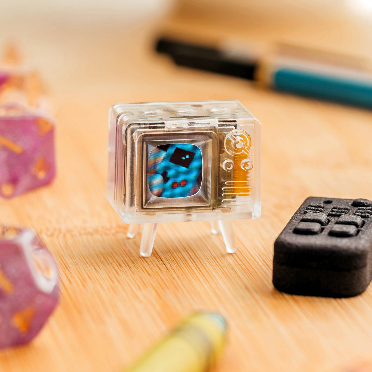 Clear TinyTV Mini with remote on a desk